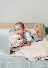 Sticker - Little girl learning online with laptop computer at bedroom.