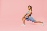 Fototapeta Panele - Full length young sporty athletic fitness trainer woman wear blue tracksuit spend time in home gym train do stretch legs squat exercise isolated on pastel plain pink background Workout sport concept