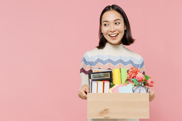 Wall Mural - Smiling teen student girl of Asian ethnicity wear sweater backpack hold books hold box of stationery look aside isolated on pastel plain light pink background Education in university college concept.