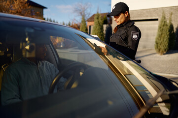 Wall Mural - Young policewoman with tablet standing near car