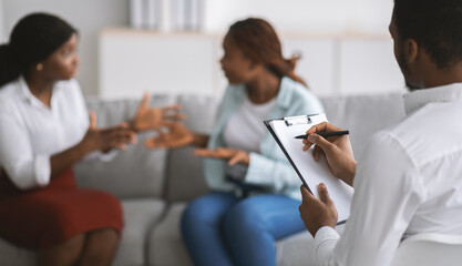 Wall Mural - Black LGBT couple having session with male psychologist at office, selective focus. Copy space