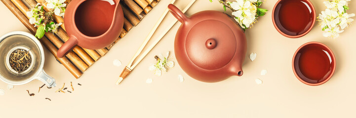 Wall Mural - Asian Tea set on stone slate board, ceramic teapot, cups, dried tea and spring branches