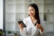 © David - Portrait of a happy Asian businesswoman using mobile phone indoor, Asian businesswoman working in modern office.