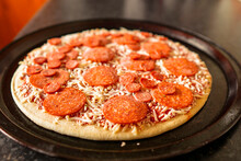 Simple Uncooked Pepperoni Pizza On A Metal Round Cooking Tray. Italian World Known Dish With Dough, Cheese And Meat And Sauce.