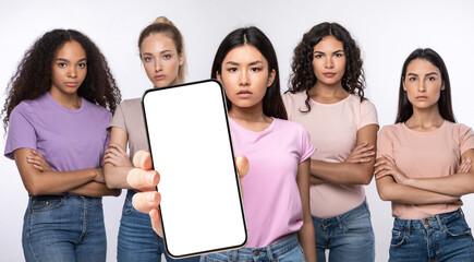 Canvas Print - Serious ladies showing blank empty smartphone screen for mockup