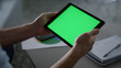 © stockbusters - Man hands using tablet device green screen research business finance in office.