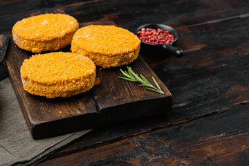 Raw fishcake Breaded, on old dark  wooden table background, with copy space for text