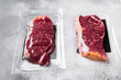 Vacuum packed beef, on gray stone table background, with copy space for text
