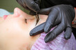 © Yulia - Cosmetologist applying permanent makeup on eyebrows Selective focus and shallow Depth of field.Mikrobleyding eyebrows workflow in a beauty salon