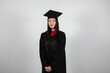 © Collab Media - Smiling graduate student in mortar board and bachelor gown on white background
