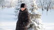 © ALEXEY - A brunette woman in winter clothes walks through the winter forest