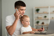 © Prostock-studio - Distance Work. Smiling Young Father Holding Little Baby And Talking On Cellphone
