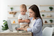 © Prostock-studio - Working Mom. Woman Using Laptop At Home And Taking Care About Baby