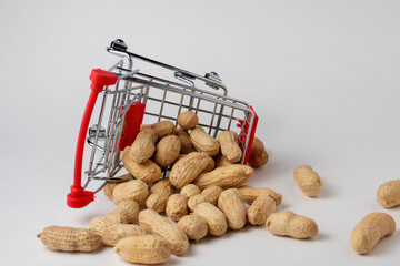 Peanuts in a nutshell in a shopping cart on a white background