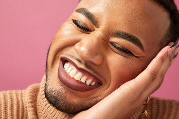 Close-up of smiling queer man against purple background