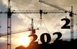© BillionPhotos.com - Silhouette of construction worker with crane and sunset sky for preparation new year of 2022 concept