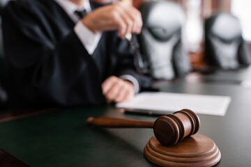 Wall Mural - selective focus of wooden gavel near cropped judge on blurred background