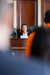 Wall Mural - prosecutor reading lawsuit near accused african american man and jurors on blurred background