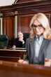 © LIGHTFIELD STUDIOS - senior grey-haired judge looking at advocate on blurred foreground