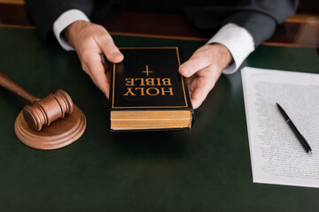 Wall Mural - partial view of judge holding bible near gavel and lawsuit in law