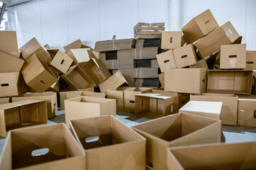 Assembled and disassembled folding cardboard boxes of perforated sheets of corrugated cardboard. Packaging of finished products in industrial production.