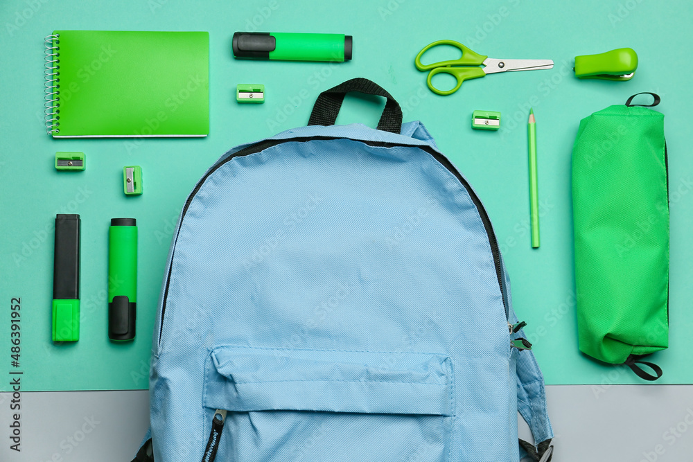 Set of different stationery with backpack on color background, closeup