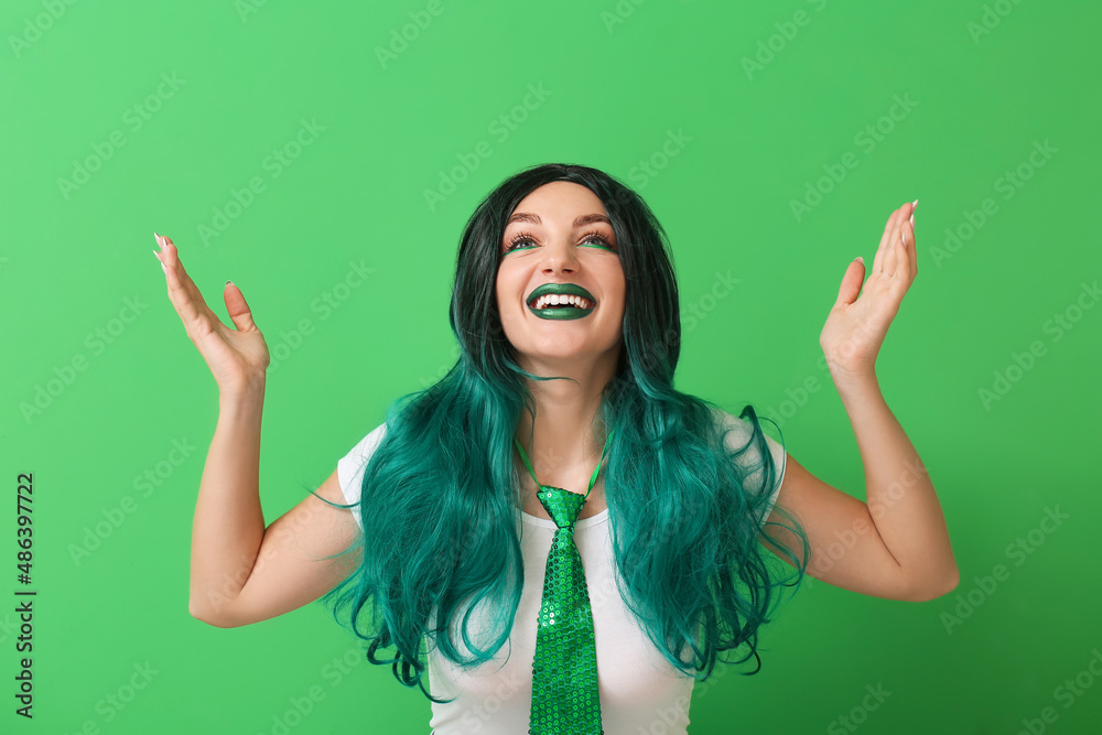 Young woman in wig on green background. St. Patrick's Day celebration