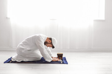 Wall Mural - Praying young Muslim man at home