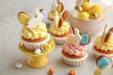 Wall Mural - Tasty Easter cupcakes and eggs on light background, closeup