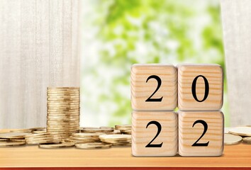 Sticker - 2022 NEW YEAR Business and saving money concept. Coins stack and blocks number 2022 on background.