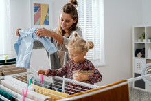 Busy Mom Spends Time With Daughter In Bathroom, Teaches Girl How To Hang Laundry On Dryer, Child Hands Woman Clothes Clips, Help With Household Chores