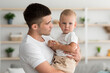© Prostock-studio - Parenthood Concept. Portrait Of Young Dad With Cute Infant Baby On Hands