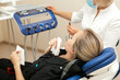 dentist a young white woman examines a patient a girl in a dental chair