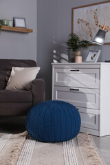 Canvas Print - Stylish knitted pouf and chest of drawers in room. Home design