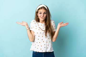 Wall Mural - Young caucasian woman over isolated background having doubts while raising hands