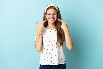 Wall Mural - Young caucasian woman over isolated background giving a thumbs up gesture