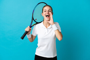 Wall Mural - Young woman tennis player isolated on blue background shouting with mouth wide open