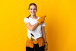 © luismolinero - Young electrician woman isolated on yellow background pointing to the side to present a product