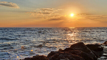 Wall Mural - colorful sunset with large sun under the sea waves.