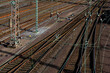 Railway tracks with switches at a big freight station shunting yard in Hagen-Vorhalle  Germany. Overhead lines, thresholds, power poles and brown gravel and rusty background. Green copper wires.
