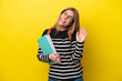 © luismolinero - Young student woman isolated on yellow background background saluting with hand with happy expression