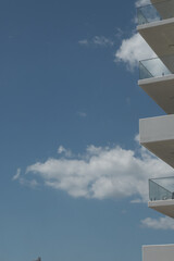 Sticker - A vertical shot of the white building balconies against the blue sky.