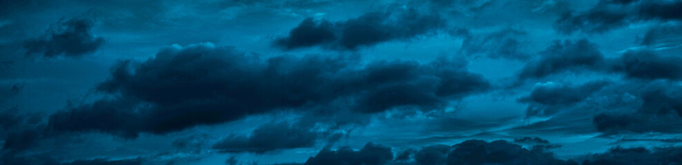 Wall Mural - clouds in the night sky. black blue skies. dark evening sky background with copy space for design. w