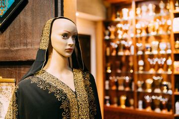 Wall Mural - Mannequins dressed in beautiful female woman traditional arabian dresses, clothes in store or outdoor market. Oriental dress in shopping center. Popular souvenirs from Dubay, UAE, United Arab Emirates