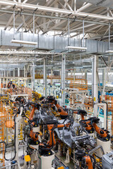 Wall Mural - Vertical photo of automobile production line. Modern car assembly plant. Auto industry. Interior of a high-tech factory, modern production