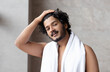 © Prostock-studio - Male morning routine. Handsome indian man with towel on shoulder standing in bathroom, copy space