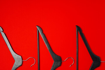 Wall Mural - Hanger on red paper background. Minimalistic fashion concept. Top view