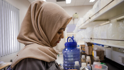 Asian girl analyze of water steam quality in the water analysis laboratory. That photos is perfect for industry pamphlet, people poster and fashion model. 