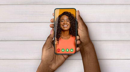Black lady holding cellphone in hand video calling friend