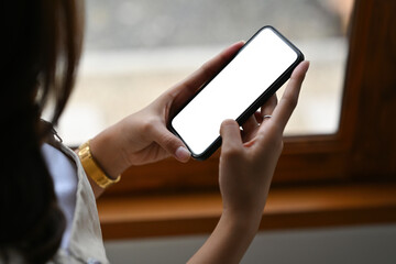 Poster - Closed up with young  woman hand using a touch screen smartphone with blank white screen. for technology and business concept.